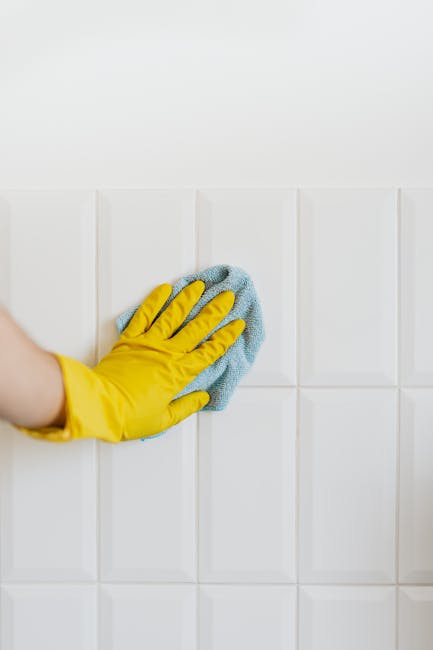 A light blue dustpan with a wooden-handled brush hanging on a white wall, illustrating a clean and organized domestic cleaning setup. The dustpan and brush appear to be new and well-maintained, suitab